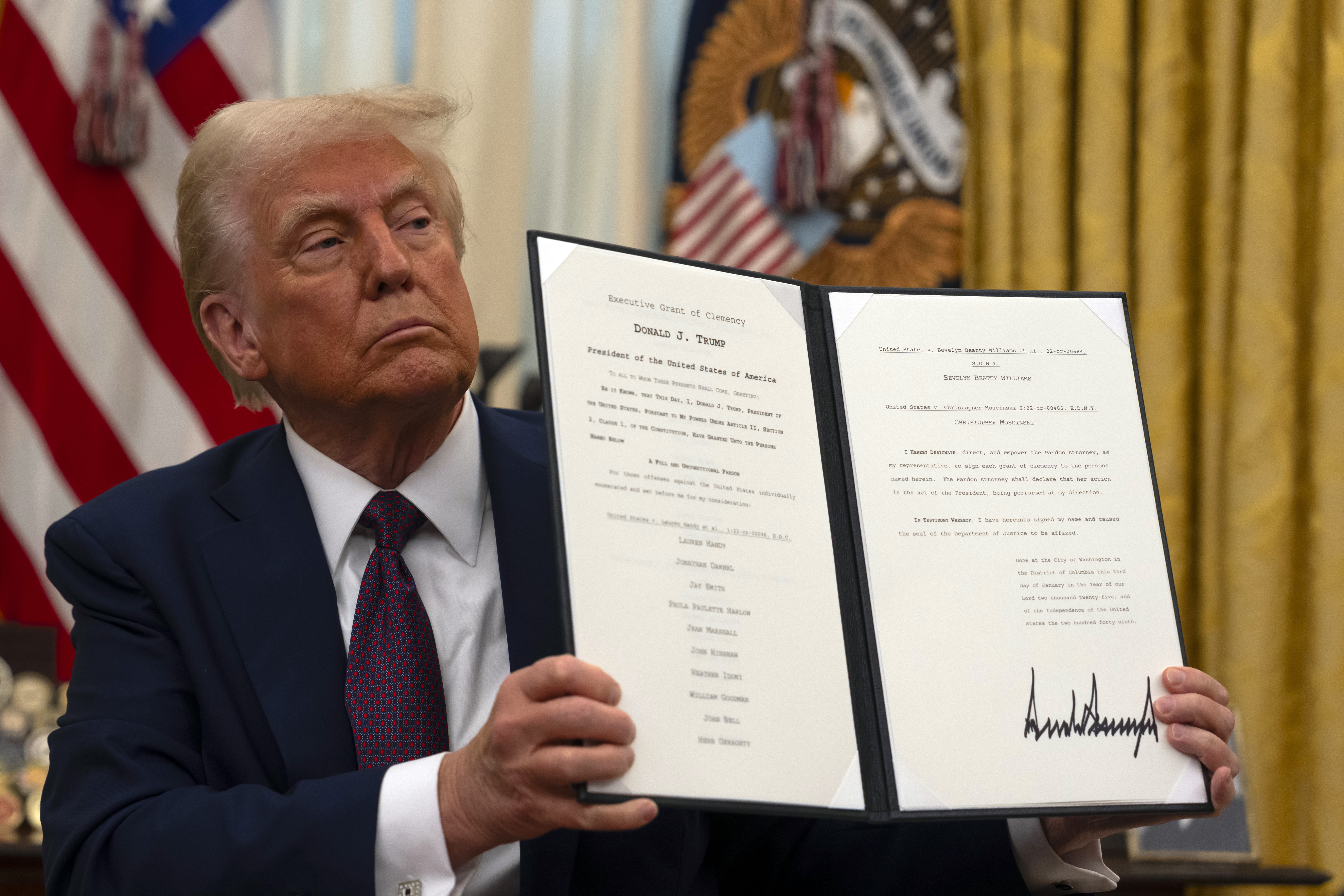 President Trump holds up a signed executive order relating to clemency for anti-abortion protesters in the Oval Office in January.